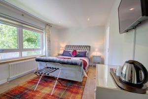 a bedroom with a bed and a couch and a television at Loch Earn in Inverness