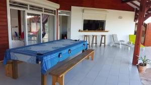 a blue ping pong table sitting on a patio at Gîte Les Palmistes in Vallée dʼOr