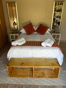 ein Schlafzimmer mit einem großen Bett und zwei Kissen in der Unterkunft Dorpsrus in Bela-Bela