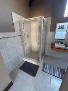 ein Badezimmer mit Dusche und Waschbecken in der Unterkunft Dorpsrus in Bela-Bela