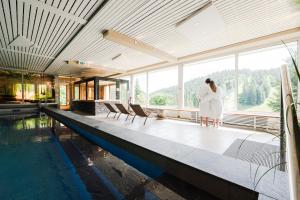 a bride and groom standing next to a swimming pool at Das Waldhotel - Spa & Wellness Resort in Todtnau
