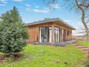 a small wooden house in a field with a tree at 2 Bed in Norwich oc-73624 in East Harling