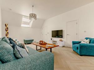 a living room with a blue couch and a table at 3 Bed in Newquay oc-90070 in Newquay
