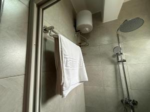 a bathroom with a shower with a white towel at Lavermo Hotel Apartments in Kampala +68 photos