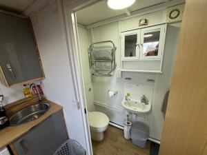 a small bathroom with a sink and a toilet at Thurso Accommodation in Castletown +14 photos