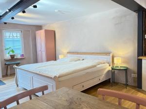 a bedroom with a large bed and a table at Katzenbachlädle in Rottenburg