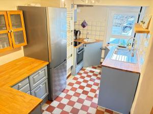 a kitchen with a stainless steel refrigerator and a checkered floor at Katzenbachlädle in Rottenburg