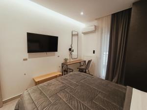 a bedroom with a bed and a desk and a television at Sodi Cozy apartment in Karditsa