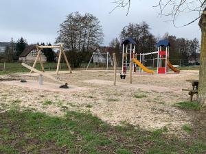 a playground with three swings and a slide at House MayFa in Riedseltz