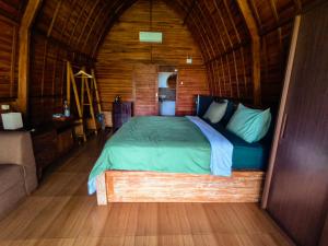 a bedroom with a bed in a wooden cabin at Sugita Wooden House 2 in Payangan +6 photos