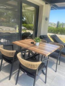 a wooden table and chairs on a patio at Ammos Luxury Pool Villas in Olympic Beach