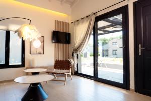 a living room with a table and a sliding glass door at Ammos Luxury Pool Villas in Olympic Beach +26 photos