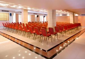 an empty lecture hall with red chairs on a platform at Xenia Poros Image Hotel by GHH in Poros