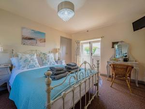 a bedroom with a bed and a table and a window at 2 Bed in Camelford oc-81245 in Camelford