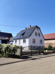 a white house with solar panels on the roof at House MayFa in Riedseltz
