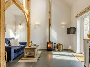 a living room with a blue couch and a fireplace at 1 Bed in Helston oc-82496 in Ruan Minor