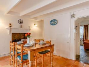 a dining room with a table and chairs and a fireplace at 2 Bed in Fowey oc-76624 in Fowey