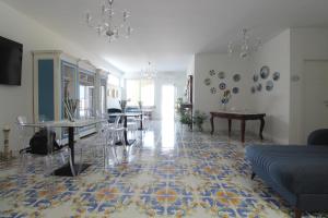 ein Wohnzimmer mit Tischen und Tellern an der Wand in der Unterkunft Paomà in Agropoli