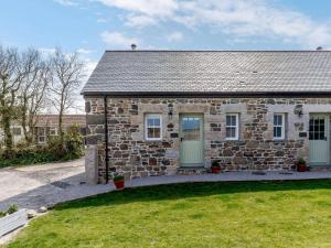 a stone house with a green door in a yard at 1 Bed in Helston oc-82496 in Ruan Minor