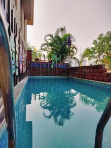 a swimming pool in front of a building at Athang Staycation in Diveagar