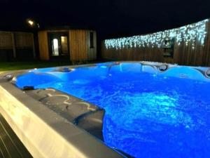 a large blue swimming pool at night with lights at 4 Bed in Bude oc-83619 in Stratton