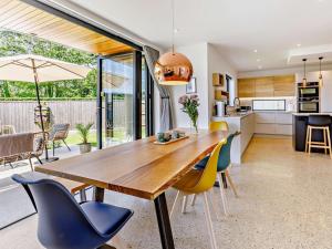 a kitchen and dining room with a wooden table and chairs at 4 Bed in Bude oc-83619 in Stratton