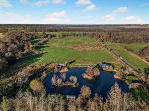 an aerial view of a golf course with a pond at 1 Bed in Norwich oc-76493 in East Harling