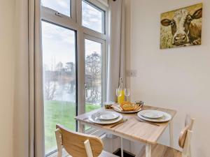 a dining room with a table and a large window at 1 Bed in Norwich oc-76493 in East Harling