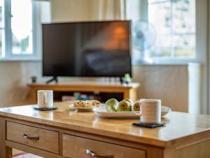 a table with a plate of food and a tv at 2 Bed in Helston oc-41378 in Cury