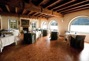 a dining room with white tables and green chairs at Hotel San Rocco in Orta San Giulio