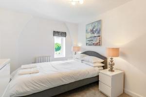 a white bedroom with a bed and a window at 2 Bed in Abersoch oc-p27804 in Abersoch