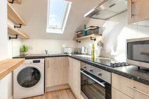 a kitchen with a washing machine and a microwave at 2 Bed in Abersoch oc-p27804 in Abersoch