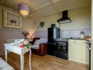 a kitchen with a stove and a table in a room at 1 Bed in Camelford oc-90818 in Camelford