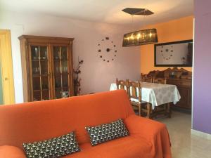 a living room with an orange couch and a table at SilvantColors Atic in Benicarló