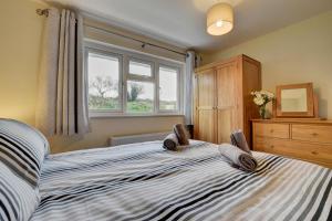 a bedroom with a bed with a dresser and a window at 3 Bed in Georgeham oc-halcy in Georgeham