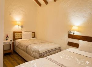 two beds in a small room with two beds at Naty's Guest House in Cusco