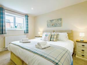 a bedroom with a large bed with towels on it at 2 Bed in Spilsby oc-91141 in Skendleby