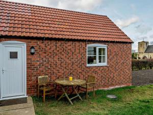 a table and chairs in front of a brick building at 2 Bed in Spilsby oc-91141 in Skendleby