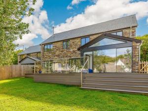 a brick house with large glass windows and a yard at 4 Bed in Bude oc-89355 in Poughill