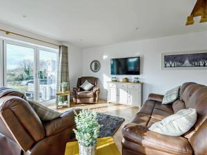 a living room with leather furniture and a tv at 3 Bed in Spilsby oc-91142 in Skendleby