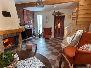 a living room with a fireplace and a table at Dom pod Aniołem in Świętajno