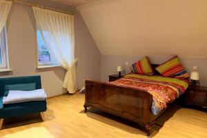 a bedroom with a bed and a couch and a chair at House MayFa in Riedseltz