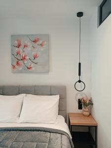 a bedroom with a bed and a painting on the wall at Sodi Cozy apartment in Karditsa