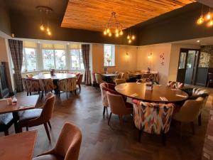 a restaurant with tables and chairs and windows at King Alfred Hotel in Barrow in Furness