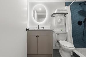 a bathroom with a toilet and a sink and a mirror at Oasis Spacious-Private Parking 16 Beds 29 Guests in Philadelphia +46 photos