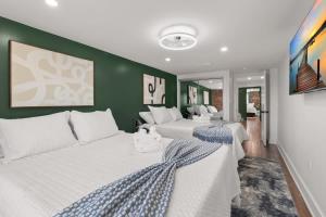 two white beds in a room with green walls at Oasis Spacious-Private Parking 16 Beds 29 Guests in Philadelphia