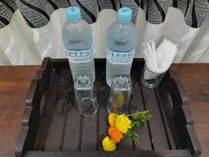 two bottles of water and flowers on a table at Hotel Diamond Palace in Bibile