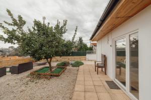 a patio with a tree next to a house at Douro Views Terrace House by Vacationy in Bandeira