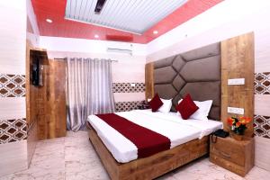 a bedroom with a large bed with red pillows at Hotel S2 Residency Near Railway Station Chandigarh in Chandīgarh +45 photos