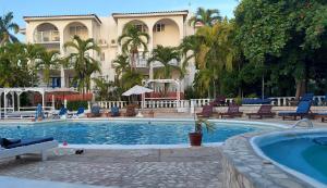 a hotel with a swimming pool and a building at Gem in Runaway Bay